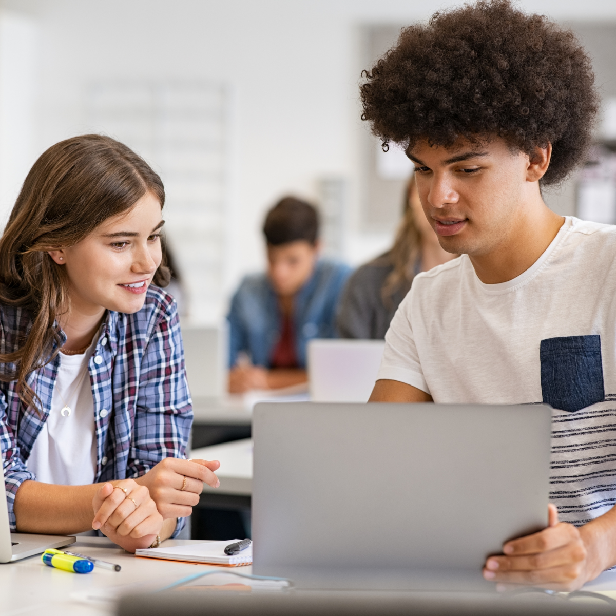 two students look at a laptop screen